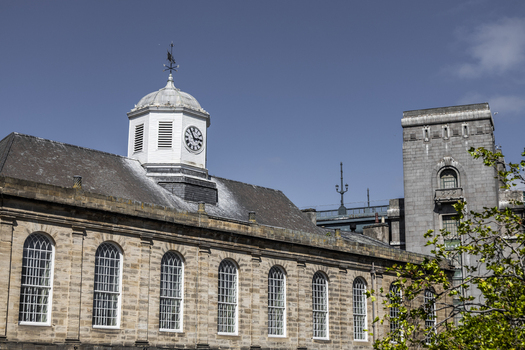 View of the historic Guildhall with its distinctive clock tower and arched windows under a clear blue sky in Newcastle upon Tyne England United Kingdom. View of the historic Guildhall with its distinctive clock tower and arched windows under a clear blue sky in Newcastle upon Tyne England United Kingdom.