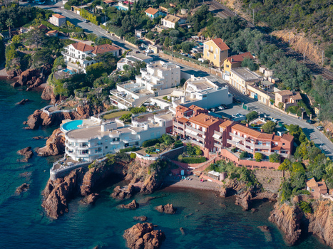 Aerial view of Le Trayas coastline featuring red rock cliffs Mediterranean sea luxury villas and coastal road Saint Raphael Provence Alpes Cote d Azur France. Aerial view of Le Trayas coastline featuring red rock cliffs Mediterranean sea luxury villas and coastal road Saint Raphael Provence Alpes Cote d Azur France.