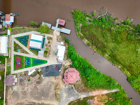 Aerial view of Urban Park featuring modern playground equipment paved walkways and lush greenery situated along the river in Alalak South Kalimantan Indonesia.