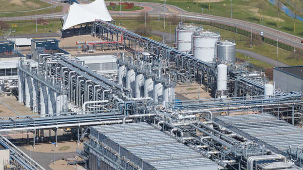 Aerial view of the Boekelermeer industrial facility with complex piping systems storage tanks and a white canopy structure under bright daylight in Alkmaar Noord Holland Netherlands. Aerial view of the Boekelermeer industrial facility with complex piping systems storage tanks and a white canopy structure under bright daylight in Alkmaar Noord Holland Netherlands.
