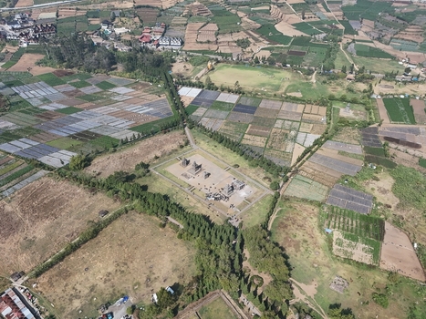 Aerial view of Arjuna Temple surrounded by agricultural fields and lush greenery in Kecamatan Batur Jawa Tengah Indonesia.