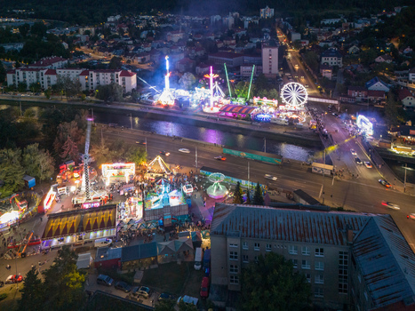 Aerial view of the illuminated Radvansky jarmok carnival rides and ferris wheel set up along the river during the traditional market in Banska Bystrica Banskobystricky kraj Slovakia.