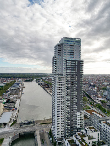 Aerial view of the modern Up site skyscraper standing tall next to the Brussels Charleroi Canal under a cloudy sky in Brussels Brussels Belgium.
