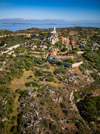 Aerial view of the Torre di Guardia Vecchia historic tower on a rocky hilltop surrounded by Mediterranean scrub and stone walls in La Maddalena Sardinia Italy. Aerial view of the Torre di Guardia Vecchia historic tower on a rocky hilltop surrounded by Mediterranean scrub and stone walls in La Maddalena Sardinia Italy.