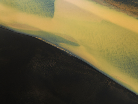 Aerial view of the glacial river s silty ochre waters meeting the stark black sands creating a mesmerizing contrast of color and texture Iceland Iceland. Aerial view of the glacial river s silty ochre waters meeting the stark black sands creating a mesmerizing contrast of color and texture Iceland Iceland.
