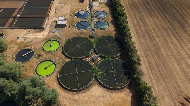 Aerial view of the wastewater treatment works featuring circular sedimentation tanks and filtration basins surrounded by agricultural fields in St Neots England United Kingdom. Aerial view of the wastewater treatment works featuring circular sedimentation tanks and filtration basins surrounded by agricultural fields in St Neots England United Kingdom.