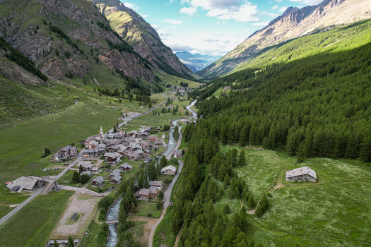 Aerial view of a picturesque village nestled in a lush alpine valley with a winding river and dense pine forests in Rhemes Notre Dame Valle d Aosta Italy. Aerial view of a picturesque village nestled in a lush alpine valley with a winding river and dense pine forests in Rhemes Notre Dame Valle d Aosta Italy.