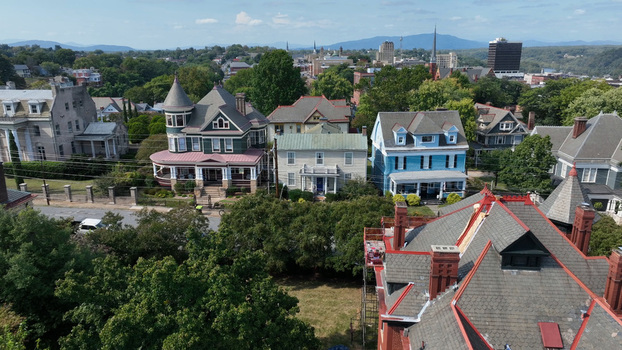 Aerial view of historic Victorian houses and residential architecture surrounded by lush green trees with the city skyline in the distance in Lynchburg Virginia United States. Aerial view of historic Victorian houses and residential architecture surrounded by lush green trees with the city skyline in the distance in Lynchburg Virginia United States.