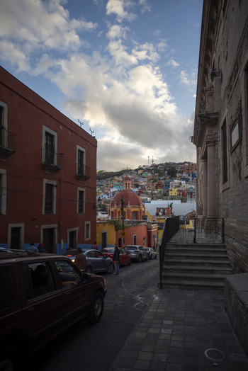View of the colorful colonial architecture and historic streets of Guanajuato Capital with a church dome in the background under a cloudy sky in Guanajuato Guanajuato Mexico. View of the colorful colonial architecture and historic streets of Guanajuato Capital with a church dome in the background under a cloudy sky in Guanajuato Guanajuato Mexico.