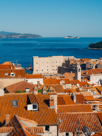 View of the terracotta rooftops of the old town and the historic St. John Fortress overlooking the blue Adriatic Sea in Dubrovnik Dubrovnik Neretva County Croatia. View of the terracotta rooftops of the old town and the historic St. John Fortress overlooking the blue Adriatic Sea in Dubrovnik Dubrovnik Neretva County Croatia.