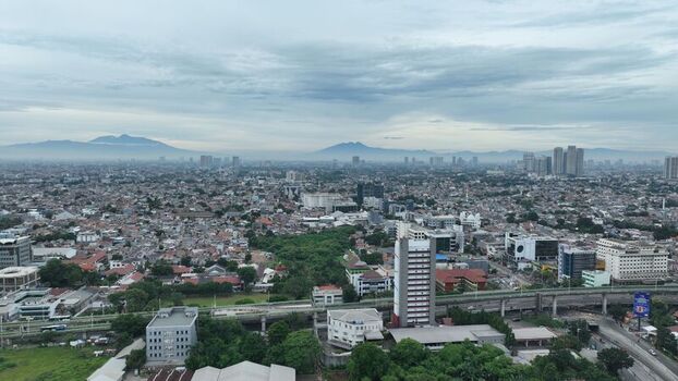 Aerial view of the dense urban landscape of Pancoran featuring residential buildings commercial high rises and an elevated highway in Pancoran Jakarta Indonesia.