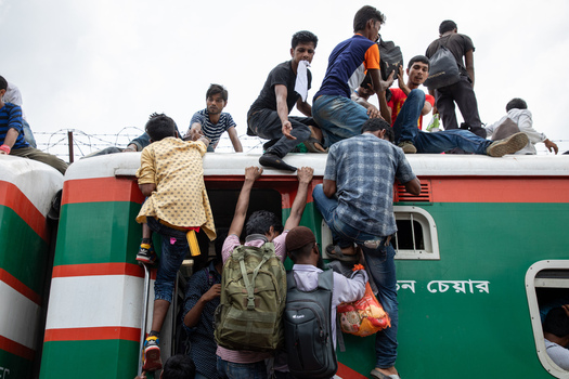 Dhaka Bangladesh 14 June 2018 View of people climbing onto the roof of a crowded train at Airport Railway Station during the Eid al Fitr holiday rush. Dhaka Bangladesh 14 June 2018 View of people climbing onto the roof of a crowded train at Airport Railway Station during the Eid al Fitr holiday rush.