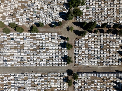 Aerial view of the cemetery with organized rows of white graves scattered trees and dirt paths in Evora Evora District Portugal. Aerial view of the cemetery with organized rows of white graves scattered trees and dirt paths in Evora Evora District Portugal.