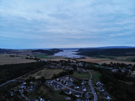 Aerial view of the Black Isle peninsula featuring residential houses and the calm waters of the bay Munlochy Scotland United Kingdom.