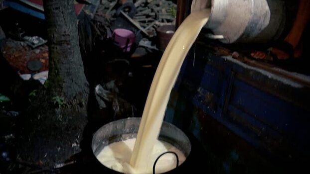 View of milk being poured from a metal container Bangladesh.