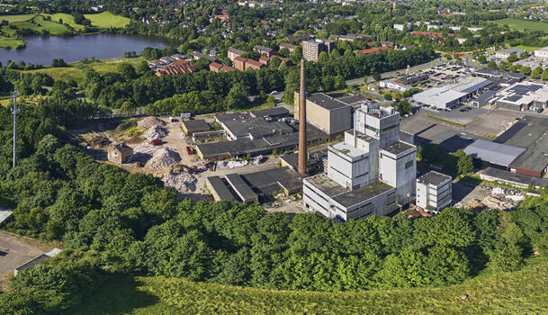 Schleswig Germany 26 June 2026 Aerial view of the former Butterwerken butter factory demolition site showing industrial buildings a tall chimney and debris amidst green trees. Schleswig Germany 26 June 2026 Aerial view of the former Butterwerken butter factory demolition site showing industrial buildings a tall chimney and debris amidst green trees.