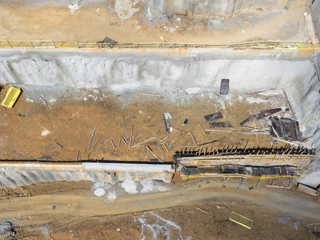 Aerial view of a deep construction site excavation with concrete retaining walls scattered building materials and scaffolding in Istanbul Istanbul Turkiye.