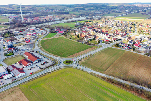 Aerial view of the town featuring a central roundabout agricultural fields residential neighborhoods and an industrial area near a river in Forchheim Bavaria Germany. Aerial view of the town featuring a central roundabout agricultural fields residential neighborhoods and an industrial area near a river in Forchheim Bavaria Germany.