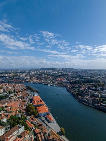 Aerial view of the historic city of Porto with its iconic terracotta rooftops lining the Douro River under a bright blue sky in Porto Porto District Portugal. Aerial view of the historic city of Porto with its iconic terracotta rooftops lining the Douro River under a bright blue sky in Porto Porto District Portugal.