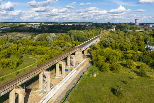 Aerial view of the Elevated Railway Viaduct spanning over lush green vegetation and trees in Poznan Greater Poland Voivod Poland. Aerial view of the Elevated Railway Viaduct spanning over lush green vegetation and trees in Poznan Greater Poland Voivod Poland.