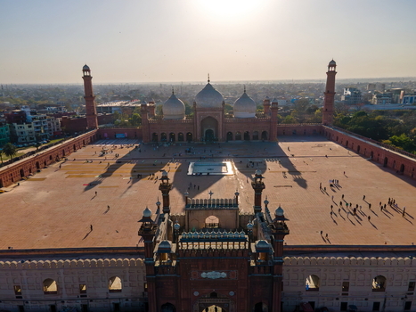 Aerial view of the historic Badshahi Mosque in Lahore featuring its large courtyard white domes and red sandstone architecture under a bright sky in Lahore Punjab Pakistan. Aerial view of the historic Badshahi Mosque in Lahore featuring its large courtyard white domes and red sandstone architecture under a bright sky in Lahore Punjab Pakistan.