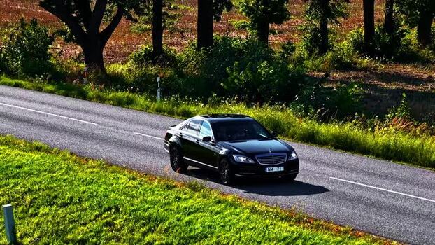 Aerial view of black Mercedes Benz sedan on rural road Latvia. Aerial view of black Mercedes Benz sedan on rural road Latvia.