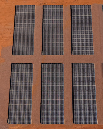 Aerial view of a solar energy installation with rows of photovoltaic panels set against the arid red earth of the landscape in Rustenburg North West South Africa. Aerial view of a solar energy installation with rows of photovoltaic panels set against the arid red earth of the landscape in Rustenburg North West South Africa.