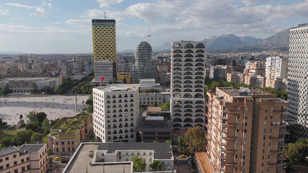 Aerial view of Skanderbeg Square surrounded by modern skyscrapers and historic buildings under a blue sky in Tirane Tirana County Albania.