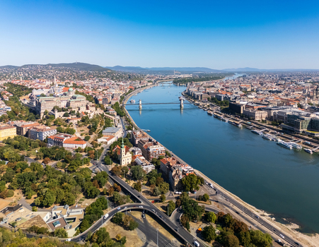 Aerial view of the Danube winding through central Budapest Hungary with Buda Castle the Szechenyi Chain Bridge riverboats historic buildings and busy embankments. Aerial view of the Danube winding through central Budapest Hungary with Buda Castle the Szechenyi Chain Bridge riverboats historic buildings and busy embankments.