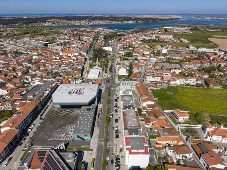 Aerial view of terracotta rooftops meet the vast Atlantic coastline bisected by a linear road leading to the horizon Póvoa de Varzim Portugal. Aerial view of terracotta rooftops meet the vast Atlantic coastline bisected by a linear road leading to the horizon Póvoa de Varzim Portugal.