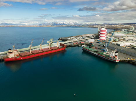 Hafnarfjordur Iceland 17 April 2026 Aerial view of the port with large cargo ships docked at the industrial pier against a backdrop of snow capped mountains and blue sea. Hafnarfjordur Iceland 17 April 2026 Aerial view of the port with large cargo ships docked at the industrial pier against a backdrop of snow capped mountains and blue sea.