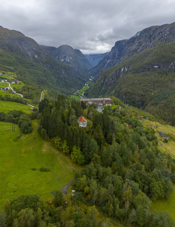 Aerial view of Stalheim Hotel on a ridge overlooking the deep Naeroydalen valley and steep mountains in Vossestrand Vestland Norway.