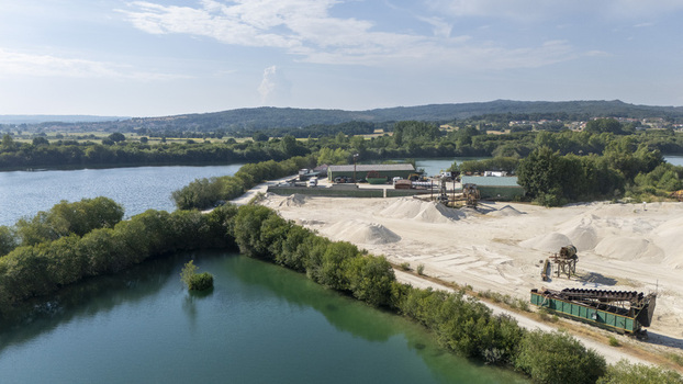 Aerial view of the Extraccion de aridos Lima S.L. industrial site with sand piles machinery and processing equipment along the riverbank in Vilarino das Poldras Ourense Spain. Aerial view of the Extraccion de aridos Lima S.L. industrial site with sand piles machinery and processing equipment along the riverbank in Vilarino das Poldras Ourense Spain.