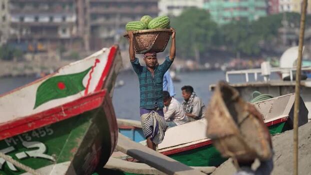 View of a man carrying watermelons at Sadarghat Bangladesh.