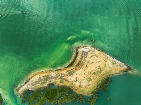 Rangamati Hill District Chittagong Division Bangladesh 18 May 2024 Aerial view of Kaptai Lake with green waters a small island and a boat navigating the surface.