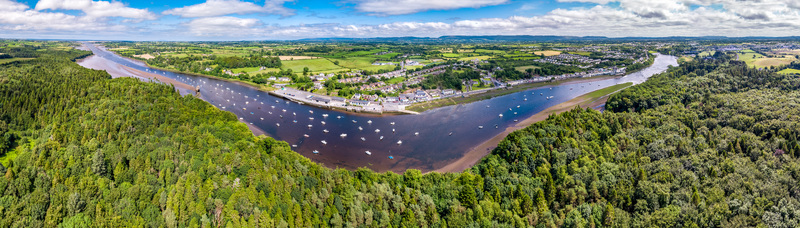 Aerial view of the River Moy winding through the town with moored boats lush green forests and residential areas in Ballina County Mayo Ireland.