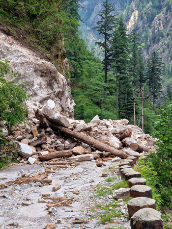 View of a landslide blocking a mountain road with fallen rocks debris and tree trunks near Malana Himachal Pradesh India.