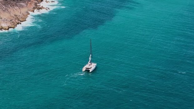 Aerial view of a catamaran sailing on turquoise waters Seychelles.