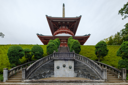 View of a majestic multi tiered pagoda rises above manicured green hills and a symmetrical stone staircase a blend of architectural grandeur and nature s artistry Narita Chiba Japan. View of a majestic multi tiered pagoda rises above manicured green hills and a symmetrical stone staircase a blend of architectural grandeur and nature s artistry Narita Chiba Japan.