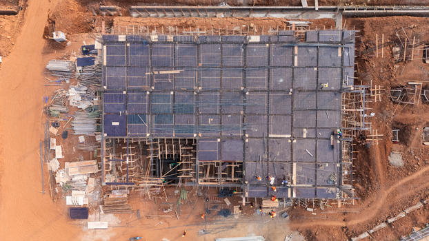 Aerial view of the Kawasan Industri Terpadu Batang construction site showing the building foundation with rebar grids formwork and workers in Kecamatan Gringsing Jawa Tengah Indonesia.