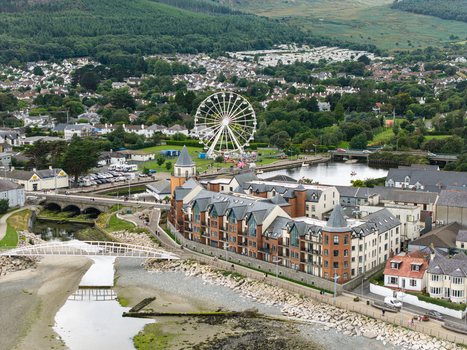 Aerial view of the Ferris wheel situated near the river and residential buildings in Newcastle Northern Ireland United Kingdom. Aerial view of the Ferris wheel situated near the river and residential buildings in Newcastle Northern Ireland United Kingdom.
