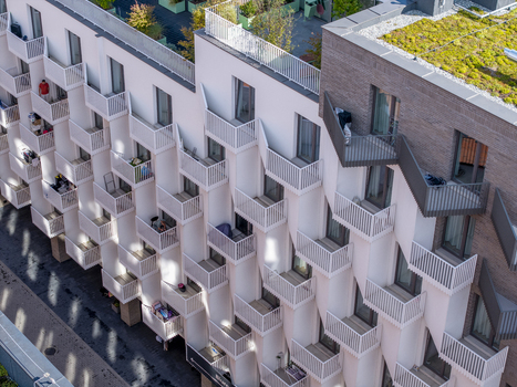 Aerial view of a modern residential building with repeating white balconies geometric facade patterns and a green roof in Krakow Lesser Poland Voivode Poland.
