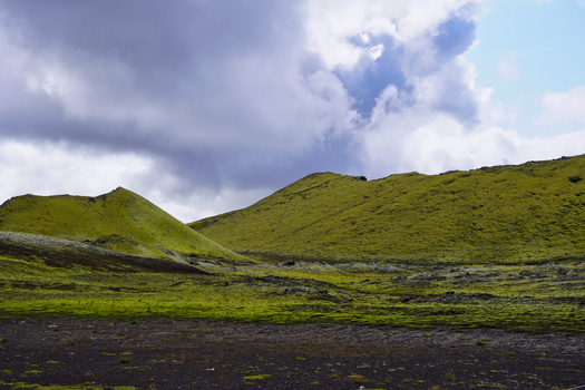 View of the moss covered volcanic hills of the Laki crater area under a cloudy sky in Kirkjubaejarklaustur Skaftarhreppur Iceland. View of the moss covered volcanic hills of the Laki crater area under a cloudy sky in Kirkjubaejarklaustur Skaftarhreppur Iceland.