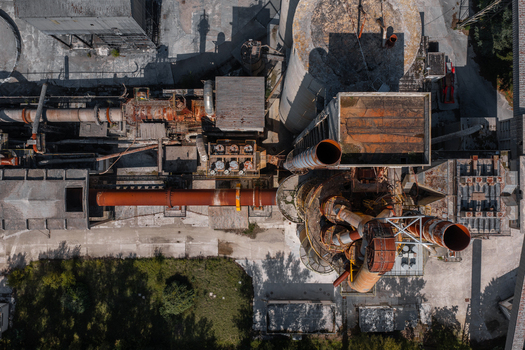 Aerial view of the Sacci S.P.A. cement factory featuring industrial pipes tall silos and rusted metal structures in Castelraimondo Marche Italy. Aerial view of the Sacci S.P.A. cement factory featuring industrial pipes tall silos and rusted metal structures in Castelraimondo Marche Italy.