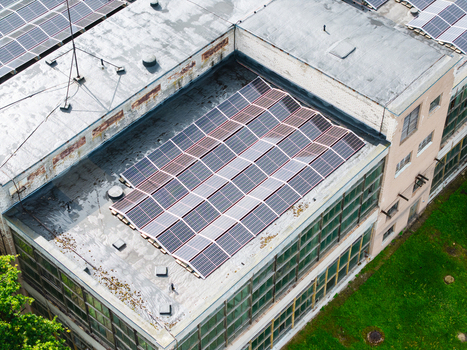 Aerial view of solar panels installed on the roof of an industrial building surrounded by green space in Olaine Olaine Municipality Latvia. Aerial view of solar panels installed on the roof of an industrial building surrounded by green space in Olaine Olaine Municipality Latvia.