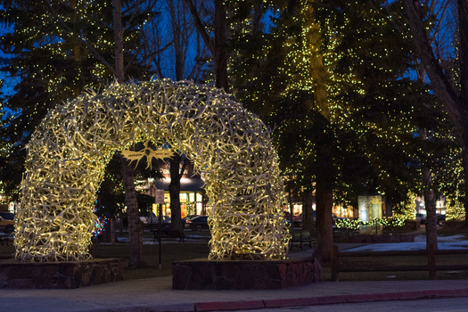 View of the iconic antler arch illuminated with festive lights in the town square of Jackson Hole Teton County Wyoming United States.