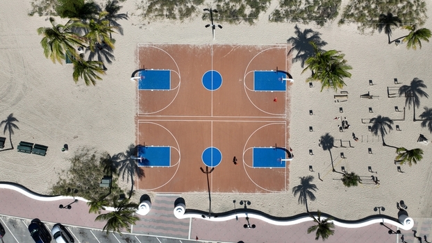 Aerial view of the contrasting brown and blue basketball courts surrounded by sandy beaches and palm trees Fort Lauderdale Florida United States.