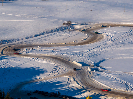 Aerial view of cars driving on a winding snow covered track during a winter rally in Moletai Utena County Lithuania.