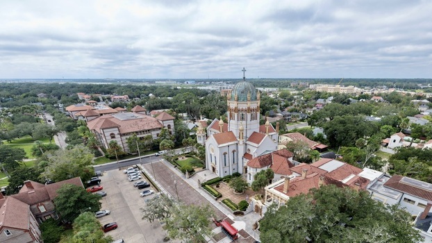 Aerial view of the Memorial Presbyterian Church with its distinctive copper dome and red tile roofs surrounded by the historic urban landscape of St. Augustine Florida United States.