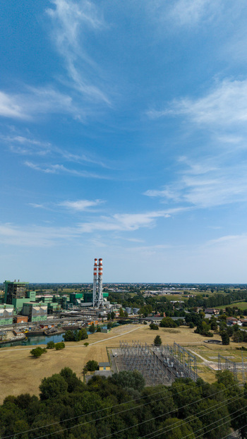 Aerial view of the TTEP Tavazzano thermal power plant and TERNA electrical substation with industrial chimneys and surrounding fields in Tavazzano con Villavesco Lombardy Italy.